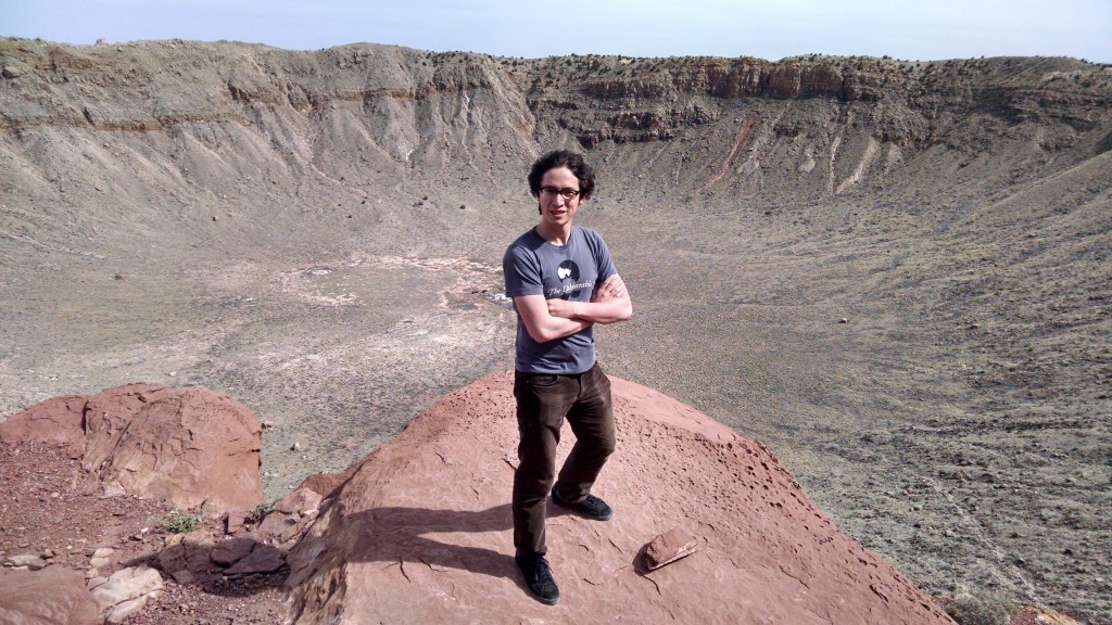 Jeffrey Young in casual clothes standing at the huge meteor crater in Meteor Crater, Arizona